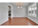 Elegant dining room with hardwood floors, decorative moldings, modern chandelier and bright natural light at 56 Addison Woods Dr, Sugar Hill, GA 30518