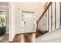 Inviting foyer featuring hardwood floors, staircase with wrought iron railing, and a view of the front door at 5925 Whitney Ct, Cumming, GA 30041