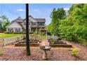 Landscaped backyard featuring raised garden beds, a white picket fence, and a charming pergola, perfect for outdoor enjoyment at 13 Westbrook Rd, Carrollton, GA 30116