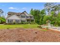 Well-maintained home featuring a sprawling lawn, landscaping, and a classic white picket fence on a sunny day at 13 Westbrook Rd, Carrollton, GA 30116
