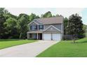 Inviting two-story home with a long driveway, manicured lawn, and a two-car garage at 4687 Riley Run Ct, Sugar Hill, GA 30518