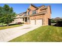 Angle view of the two-story brick home with an extended driveway, landscaped yard, and attached two-car garage at 1021 Reddy Farm Rd, Grayson, GA 30017