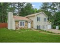 Two-story home featuring light siding, stone accents, attached garage, and a well-manicured front lawn at 2959 Pritchards Mill Trl, Douglasville, GA 30135