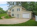 Two-story home featuring light siding, stone accents, attached garage, and a grassy front lawn at 2959 Pritchards Mill Trl, Douglasville, GA 30135