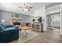 Cozy living room featuring wood floors, a stone fireplace, and an open view of the kitchen at 2959 Pritchards Mill Trl, Douglasville, GA 30135