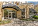 Building entrance with a black awning over glass doors, surrounded by flower beds and green foliage at 870 Inman Village Ne Pkwy # 305, Atlanta, GA 30307