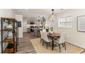 Open dining area features a modern light fixture, wood flooring, and a smooth transition into the kitchen at 1062 Grant Terrace, Atlanta, GA 30315