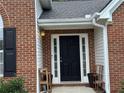 Up-close front door view featuring black door, sidelights, and brick exterior at 3690 Crescent Walk Ln, Suwanee, GA 30024