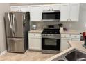 Modern kitchen features stainless steel appliances and white cabinets at 3690 Crescent Walk Ln, Suwanee, GA 30024
