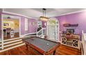 Recreation room with pool table, wet bar, hardwood flooring, and bright purple walls at 4259 Kings Troop Rd, Stone Mountain, GA 30083