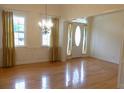 Bright living room featuring hardwood floors, large windows with gold curtains, and an elegant chandelier at 430 English Ivy Way, Woodstock, GA 30188