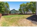 Spacious grassy backyard featuring a partial view of the wooden fence and neighboring trees at 795 Creek Glen Rd, Mableton, GA 30126