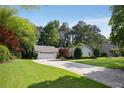 Single-story home with an attached garage, long driveway, and mature trees enhancing the property's appeal at 3519 Oak Knoll Dr, Marietta, GA 30068