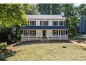Charming two-story home with inviting front porch, manicured lawn, and traditional architectural details at 4166 Riverhill Ne Ct, Roswell, GA 30075