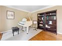 Living room featuring a white piano, hardwood floors, and built in bookshelves at 4402 Windsor Oaks Chase, Marietta, GA 30066