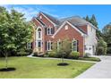 Charming two-story brick home with manicured front lawn, mature landscaping, and driveway at 2330 Springmonte Pl, Cumming, GA 30041