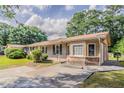 Charming brick home with mature trees, a well-manicured lawn, and a private driveway at 3420 Leisure Ln, Atlanta, GA 30349