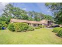 Attractive single-story home with a lush green lawn, mature trees, and a welcoming facade at 3420 Leisure Ln, Atlanta, GA 30349