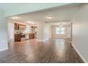 Open-concept living space with luxury vinyl plank flooring, modern lighting, and stainless steel appliances at 3420 Leisure Ln, Atlanta, GA 30349