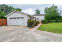View of the home's exterior and garage, featuring manicured bushes and lush lawn at 456 Harmony Grove Rd, Lilburn, GA 30047