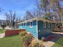 Beautiful exterior view of a blue home with a brick foundation and manicured landscaping at 81 Burbank Nw Dr, Atlanta, GA 30314