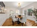 Elegant dining room with wood floors, wainscoting, a modern chandelier, and large windows at 1195 Cameron Ct, Atlanta, GA 30306