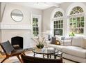 Bright living room with a decorative fireplace, arched windows, and stylish modern furniture at 1195 Cameron Ct, Atlanta, GA 30306