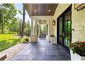 Inviting covered porch with stone columns, gray tile floor, and a porch swing at 306 Pinecrest Ne Rd, Atlanta, GA 30342