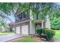 Two-story home with a brick facade, a two-car garage, and lush front yard landscaping at 3469 Stoneleigh Walk, Lithonia, GA 30038