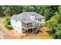 Rear exterior view featuring a screened porch, back deck with stairs, and multi-car garage at 567 Leah Drive, Powder Springs, GA 30127