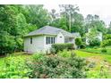 View of a cozy home with lush greenery, landscaping, and a detached garage at 567 Leah Drive, Powder Springs, GA 30127