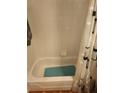 Clean white bathtub with a shower curtain and tiled walls. Features a green bath mat at 1075 Peachtree Ne Walk # 506, Atlanta, GA 30309