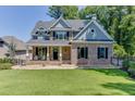 Charming two-story home boasts a brick facade, manicured lawn, and a welcoming front porch with rocking chairs at 3441 Shoreland Dr, Buford, GA 30518