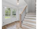 Bright foyer featuring hardwood floors, staircase with black iron railings, and stylish lighting, creating a welcoming ambiance at 3981 Longview Dr, Chamblee, GA 30341
