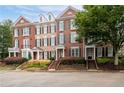 Attractive brick townhomes featuring a well-kept landscape, front entrances, and traditional design elements at 4503 Kendall Way, Roswell, GA 30075