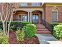 Covered front porch entrance features a brick staircase and columns at 10125 Brixton Pl, Suwanee, GA 30024