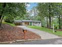 Quaint renovated home with white painted brick, a teal front door, and long driveway at 3356 Thornewood Dr, Atlanta, GA 30340