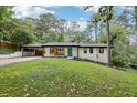 Charming renovated home with white painted brick and a teal front door, nestled on a lush, tree-filled lot at 3356 Thornewood Dr, Atlanta, GA 30340