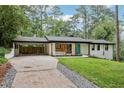 Well maintained home with white painted brick, a teal front door, and convenient covered parking at 3356 Thornewood Dr, Atlanta, GA 30340