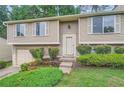 Charming home exterior featuring a one-car garage and manicured front yard with bushes at 4470 Hopkins Lake Nw Dr, Duluth, GA 30096