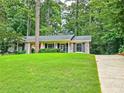 Beautifully landscaped home with a lush green lawn, mature trees, and a red front door creating a warm, inviting entrance at 773 N Superior Ave, Decatur, GA 30033