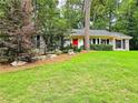 Beautifully landscaped home with a lush green lawn, mature trees, and a red front door creating a warm, inviting entrance at 773 N Superior Ave, Decatur, GA 30033