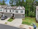 Gray two-story townhouse with a one car garage, concrete driveway and beautiful lawn at 153 Witter Way, Woodstock, GA 30188