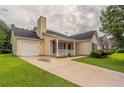 A cozy, light yellow home with a well-manicured lawn, attached garage, and inviting entrance at 3673 Jervis Ct, Rex, GA 30273