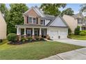 Charming two-story home featuring a welcoming front porch, two-car garage, and a well-manicured lawn at 4266 Suwanee Brook Ct, Buford, GA 30518