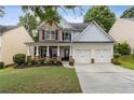 Charming two-story home featuring a welcoming front porch, two-car garage, and a well-manicured lawn at 4266 Suwanee Brook Ct, Buford, GA 30518