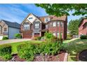 Charming brick and stone home with well-maintained landscaping and a three-car garage at 3642 Lake Estates Way Way, Atlanta, GA 30349