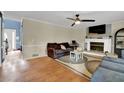 Inviting living room with a brick fireplace, hardwood floors, ceiling fan and ample natural light at 3897 Tanbark Ct, Marietta, GA 30066
