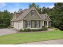 Side view of an elegant home with a three-car garage, beautiful landscaping, and a well-kept lawn at 414 Wallis Farm Way, Marietta, GA 30064