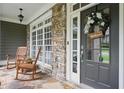 Inviting front porch with rocking chairs, stone accents, and a welcoming wreath on the front door at 414 Wallis Farm Way, Marietta, GA 30064